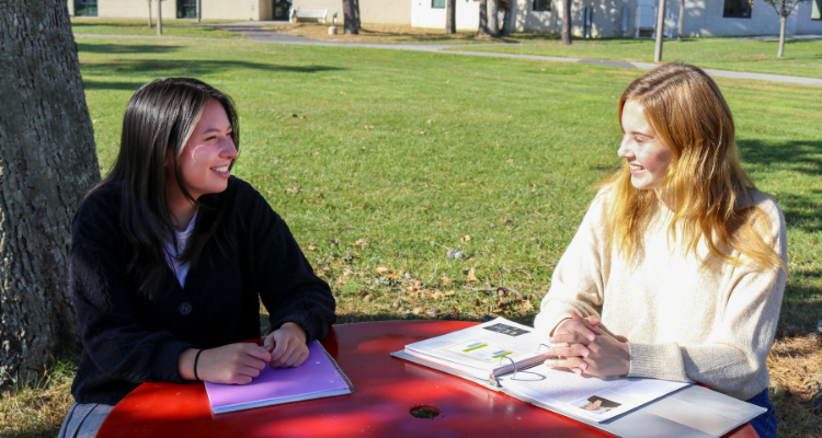 Absegami High School seniors Zoe Greblunas and Daphne Kershenblatt sit at a picnic table on Atlantic Cape's Mays Landing campus 